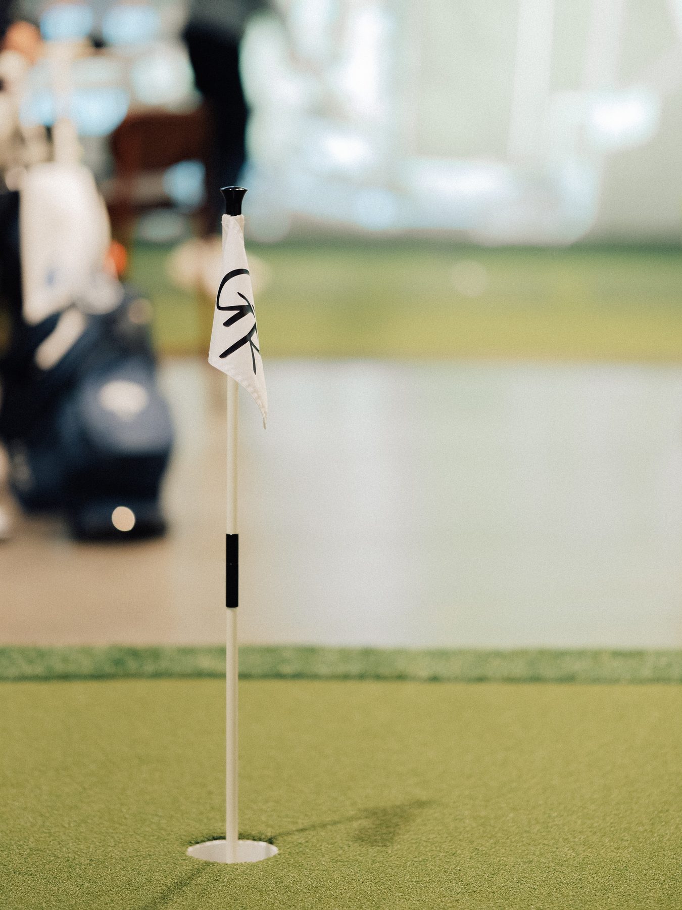 The Green Room putting green with a club flag
