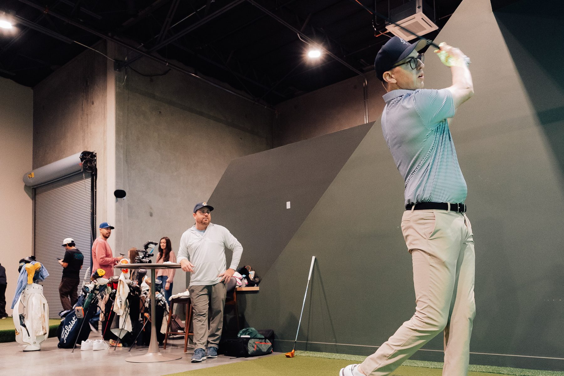 A golfer finishing his swing on the Green Room floor