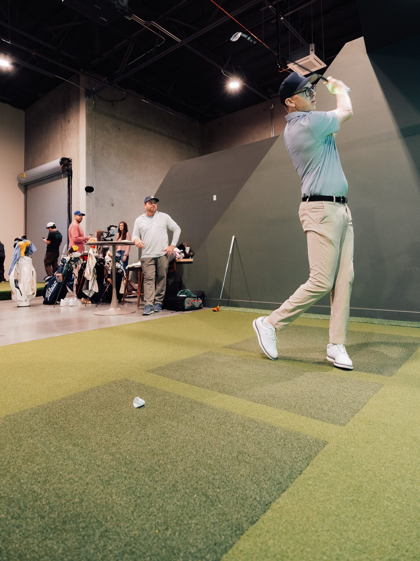 A golfer finishing his swing on the Green Room floor
